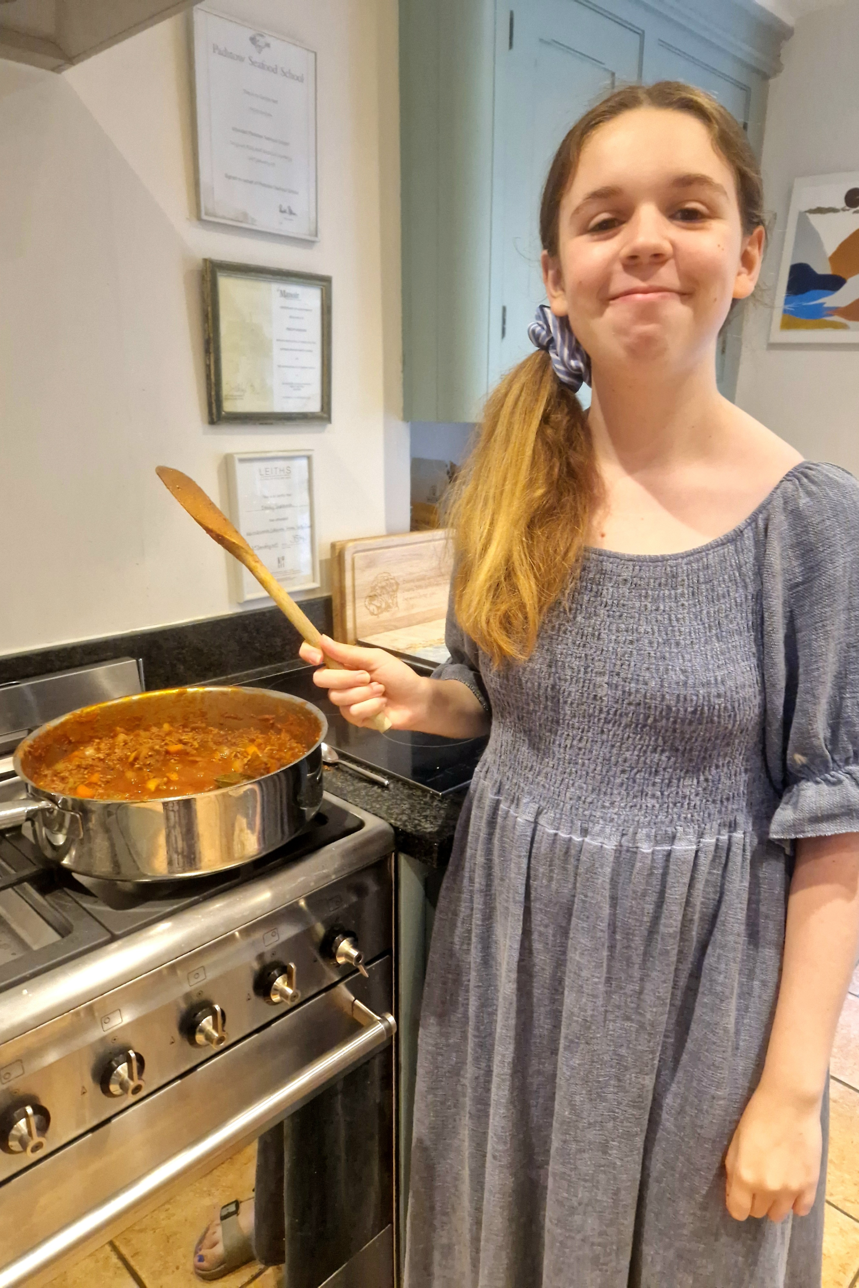 Estella cooking spaghetti bolognse sauce on stove